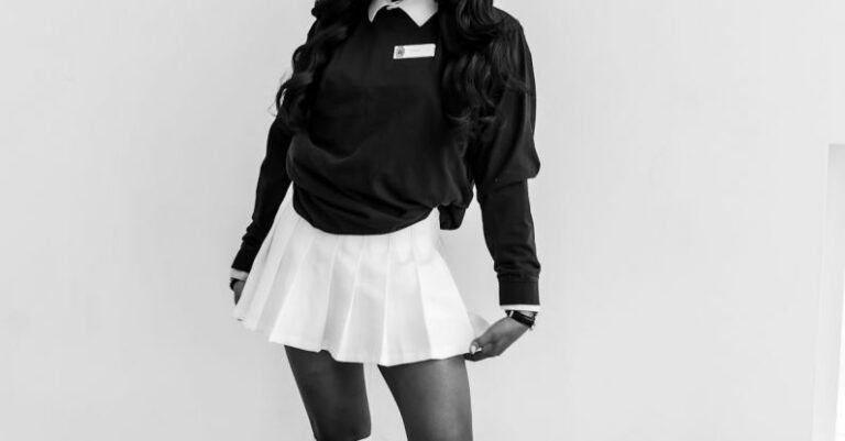 Smart Fitness - Full length of black and white African American female in trendy school uniform and eyeglasses standing near wall and looking at camera