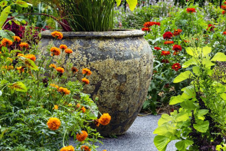 Garden Feature - a large vase sitting in the middle of a garden filled with flowers