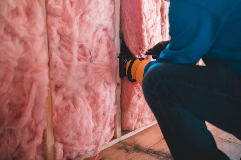 Home Insulation - person in blue pants sitting on brown wooden floor
